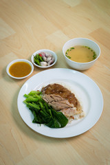 Stewed pork leg on rice with Boiled eggs on the wood table, Thai Food