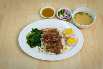 Stewed pork leg on rice with Boiled eggs on the wood table, Thai Food
