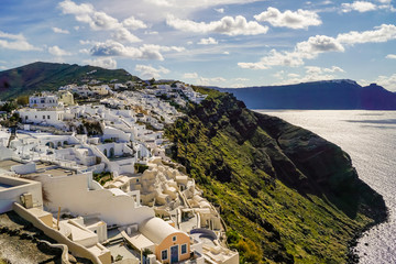 White houses near Aegean sea against sky with clouds in Greece