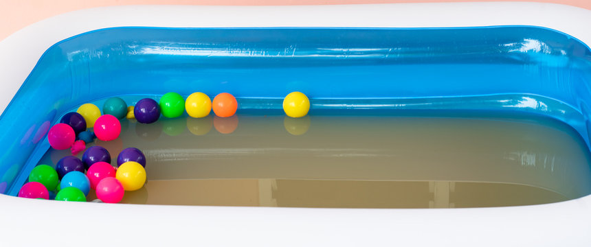 The Blue Inflatable Pool Inside Has Many Colored Balls.