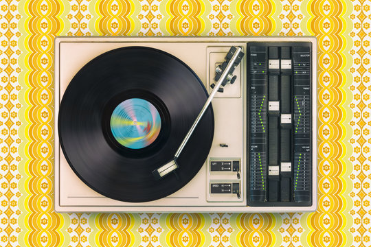 Retro styled image of an old record player on top of flower wallpaper