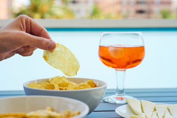 young man taking a potato chip from a bowl