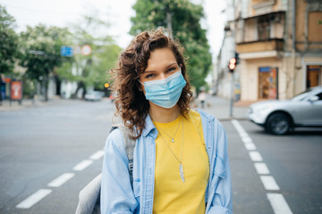 Portrait of happy young woman wearing protective medical mask