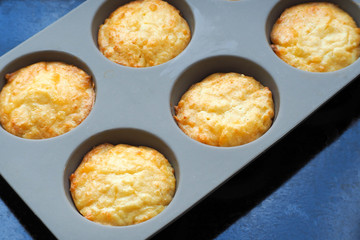 yellow cheese muffins made of cottage cheese, eggs and rice flour in a gray silicone form . gluten-free food prepared at home. bakery products