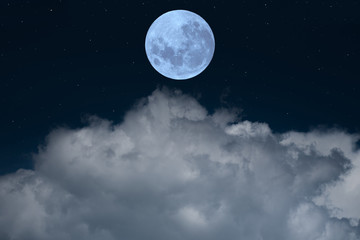 Full moon over clouds in the night.