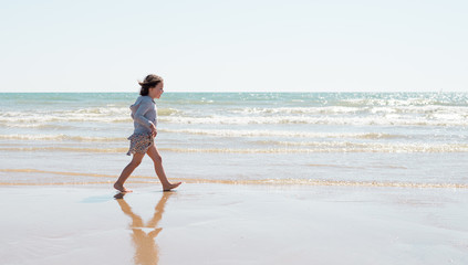 Young girl enjoying the beach on a beautiful sunny day