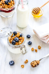 Fitness breakfast with granola, milk and honey on white background