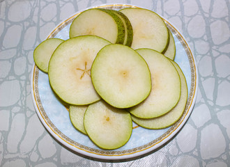 Ripe pear cut into circles on a plate. Healthy fruits.