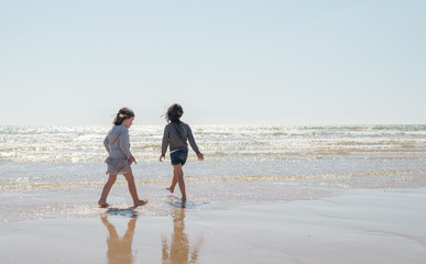 Two young girls enjoying the beach on a beautiful sunny day. French lifestyle