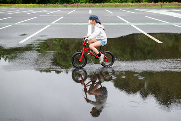 水溜まりで自転車に乗る女の子