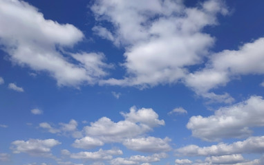 White cumulus clouds on blue sky background