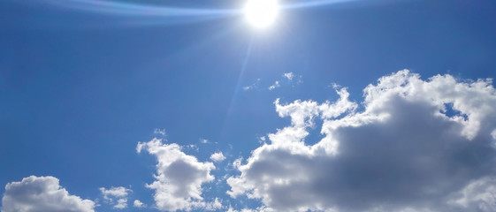 Bright sun over clouds on blue sky background