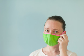 woman in green
protective mask on a light blue background