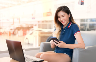 An Asian woman is working at a car testing service center.