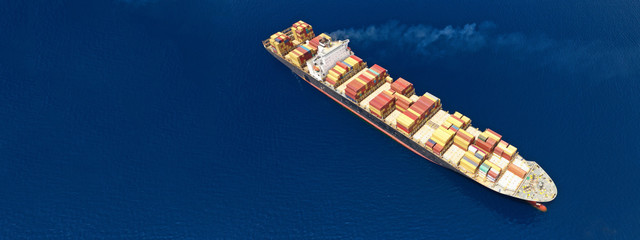 Aerial drone panoramic photo of industrial container tanker cruising in open ocean deep blue sea	
