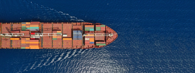 Aerial drone panoramic photo of industrial container tanker cruising in open ocean deep blue sea	
