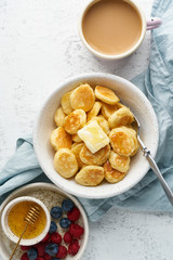 Pancakes cereal, tiny thin funny crumpet, children's food. Breakfast with drink