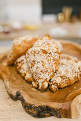 Almond croissants on a wooden plate. Coffee shop concept.