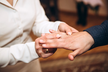 The bride and groom wear wedding rings. A young couple at a wedding ceremony. hands closeup.