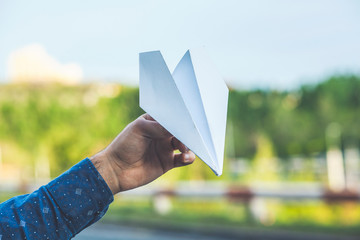 man holding paper plane in his hand