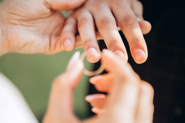 The bride and groom wear wedding rings. A young couple at a wedding ceremony. hands closeup.