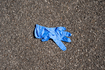 a blue surgical glove abandoned in the street.