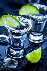 Alcohol party with tequila, ice and salt on black background