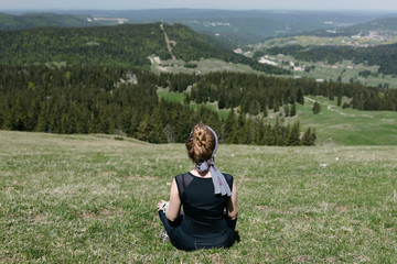 The girl does exercises from yoga on the background of a mountain landscape.