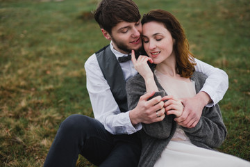 Romantic, young and happy caucasian couple in wedding clothes hugging on the background of beautiful mountains. Love, relationships, romance, happiness concept. Bride and groom traveling  together.