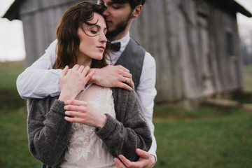 Romantic, young and happy caucasian couple in wedding clothes hugging on the background of beautiful mountains. Love, relationships, romance, happiness concept. Bride and groom traveling  together.