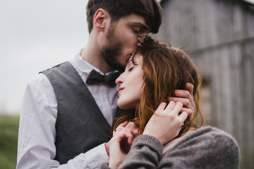 Romantic, young and happy caucasian couple in wedding clothes hugging on the background of beautiful mountains. Love, relationships, romance, happiness concept. Bride and groom traveling  together.
