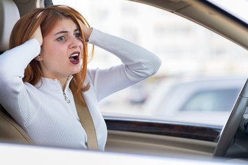 Closeup portrait of pissed off displeased angry aggressive woman driving a car shouting at someone. Negative human expression consept.
