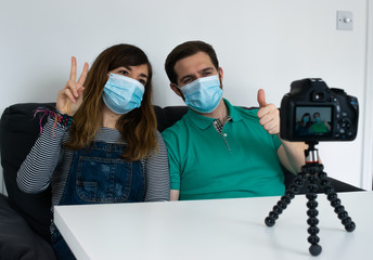 Fototapeta na wymiar Photo of a young and attractive couple wearing a face mask taking a photo with a camera with happy attitude 