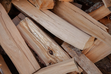 Trees in the sawmill are stacked in bags for sell. Stacks of firewood. Preparation of firewood for the winter. A heap of woodpile. Chopped wood. Firewood.Pile of wood logs ready for winter
