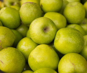 appetizing green apples on counter in market