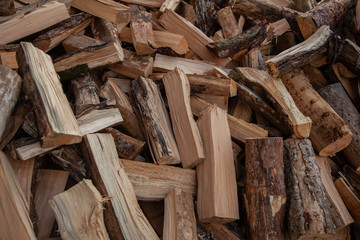 Trees in the sawmill are stacked in bags for sell. Stacks of firewood. Preparation of firewood for the winter. A heap of woodpile. Chopped wood. Firewood.Pile of wood logs ready for winter
