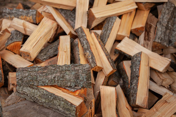 Trees in the sawmill are stacked in bags for sell. Stacks of firewood. Preparation of firewood for the winter. A heap of woodpile. Chopped wood. Firewood.Pile of wood logs ready for winter
