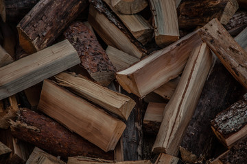 Trees in the sawmill are stacked in bags for sell. Stacks of firewood. Preparation of firewood for the winter. A heap of woodpile. Chopped wood. Firewood.Pile of wood logs ready for winter
