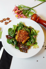 Salad with caramelized liver and couscous. Salad mix, caramelized chicken liver with apples, couscous, raspberry sauce, potato pie, walnut