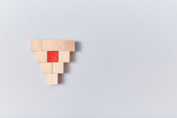 Empty wooden cube and one red, mockup style, place for text. Blank blocks in form of inverted pyramid. Isolated on blue