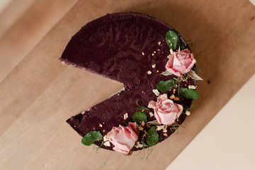 Purple cake. Dessert decorated with flowers. No piece of cake. Cut off a piece of cake. Cake cut off. 