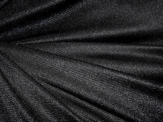 Folds of black shine fabric texture background