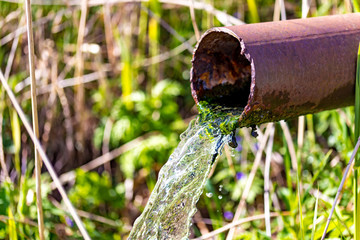 Water running from rusted metal pipe