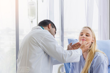 Fototapeta premium male doctor examined the neck pain of a female patient sitting in hospital bed