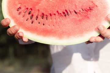 Woman holding piece of juicy sweet watermelon