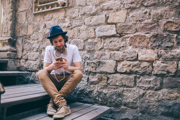 Pacified man with headphones on neck chatting on phone