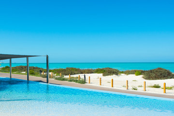 Fototapeta na wymiar Pool area with sunbeds and umbrellas in luxury hotel