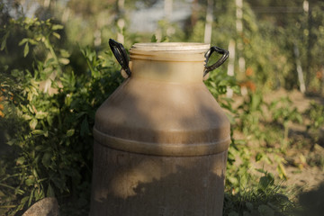 Obraz premium Close up of plastic container for liquid in the garden. Old dirty water barrel