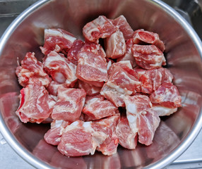 top view of raw pork bone cut in pieces in the stainless bowl