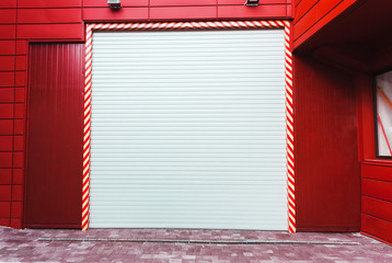 Gate automatic white with a red wall in the garage barn